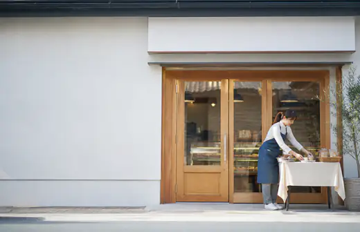 改装された小さな店舗の外観と店主